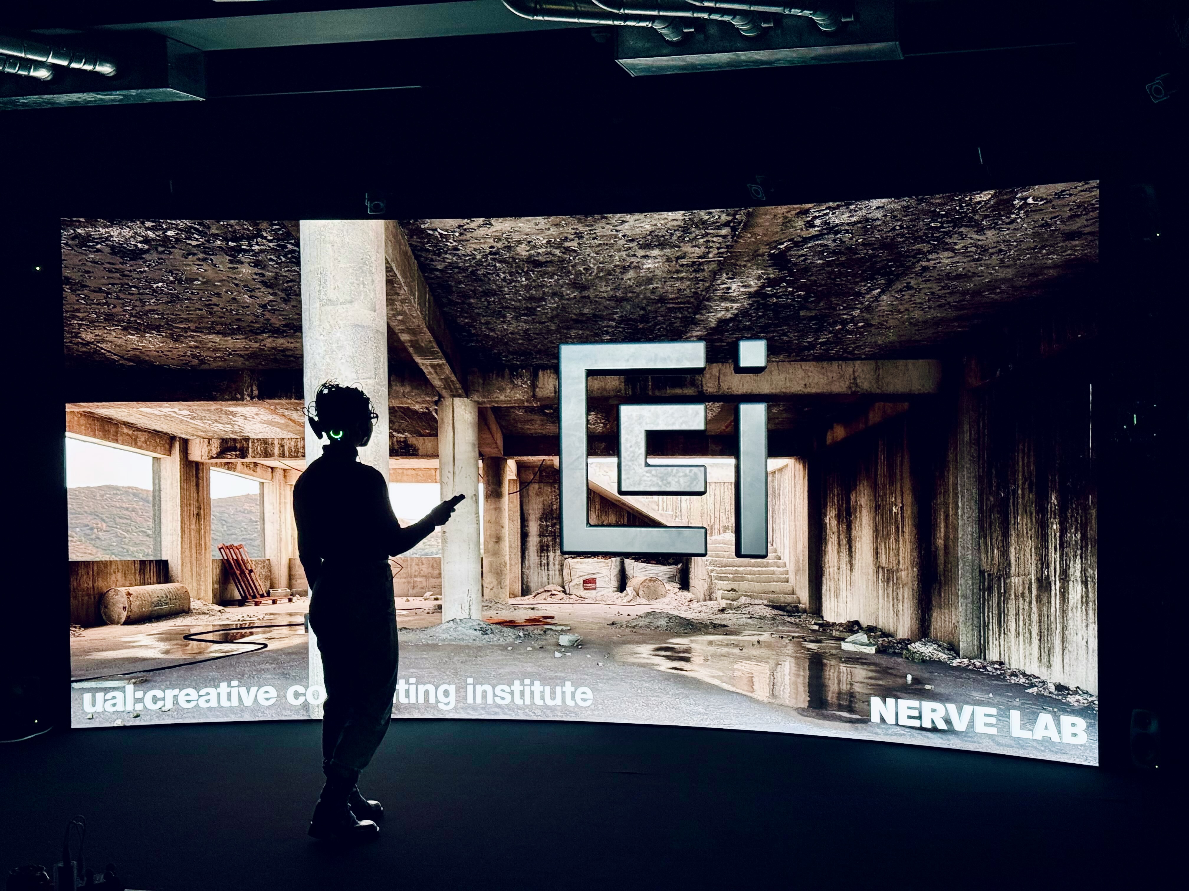 Photo of the Nerve Lab with a woman wearing an fNIRs headset in front of a large curved LED wall